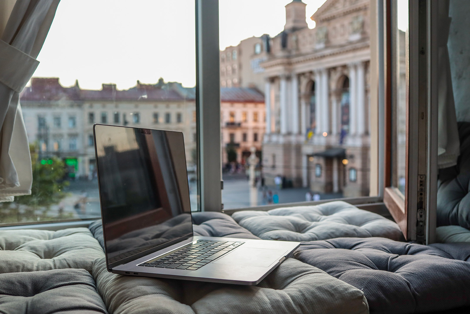 green grass field with trees and mountains in the distance